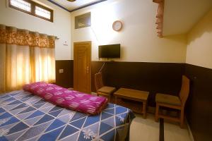 a bedroom with a bed with a pink pillow on it at Sudama Dham Homestay in Ayodhya +14 photos