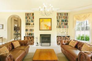 a living room with leather couches and a fireplace at Vinden Estate Homestead, Pokolbin in Pokolbin