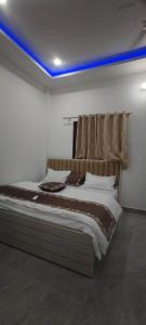 a bed in a room with a blue ceiling at Hotel Shree Ram palace ayodhya in Ayodhya