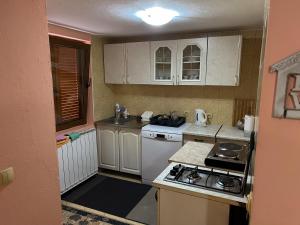 a small kitchen with white cabinets and a stove top oven at Krivaja River Retreat - Jacuzzi, Pool and Basketball 