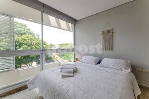 een slaapkamer met een wit bed en een groot raam bij Luxury, Bbq & Pool In Villa Morra in Asuncion +20 foto's