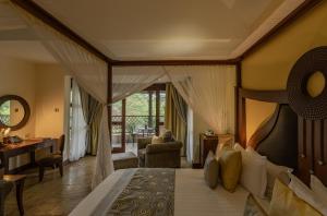 a bedroom with a canopy bed and a living room at Enashipai Resort & Spa in Naivasha