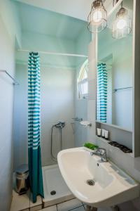a bathroom with a sink and a shower and a mirror at Velendzas Holidays in Alikanas +102 photos