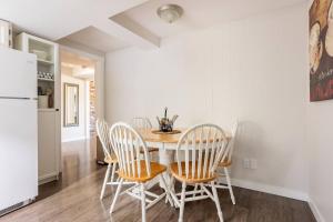 a kitchen with a table and chairs and a refrigerator at Quiet Area Near Downtown Walkable To Cafes in Maple Ridge District Municipality