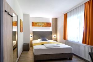 a bedroom with a bed and a large window at Vitalhotel Krainz in Loipersdorf bei Fürstenfeld