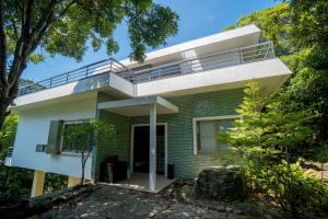 a house with a balcony on top of it at Guesthouse 湯本見山 in Hakone