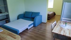 a living room with a blue couch and a table at Mereliivatee in Neeme