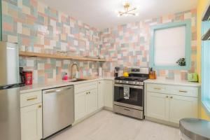 een keuken met witte kasten en een tegelmuur bij Funky Beach House Steps 2 Ocean Center & Beach in Daytona Beach
