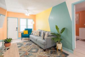 een woonkamer met een bank en een stoel bij Funky Beach House Steps 2 Ocean Center & Beach in Daytona Beach