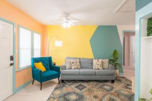 een woonkamer met een bank en een blauwe stoel bij Funky Beach House Steps 2 Ocean Center & Beach in Daytona Beach +37 foto's