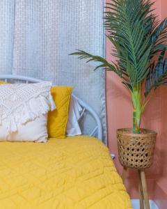 een slaapkamer met een geel bed en een potplant bij Funky Beach House Steps 2 Ocean Center & Beach in Daytona Beach