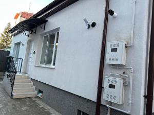 a white building with a staircase and a window at Carina Guest House in Turda