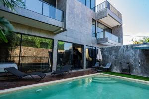 una casa con piscina al lado de un edificio en Villa Maya, en Kerobokan