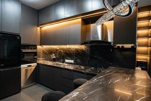 cocina con armarios negros y encimera de mármol en Villa Maya, en Kerobokan