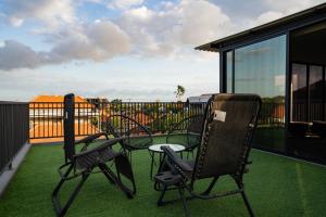 Dos sillas y una mesa en un balcón. en Villa Maya, en Kerobokan