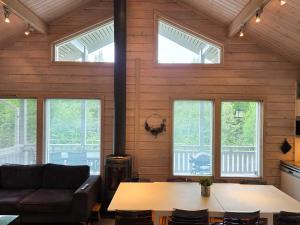 a room with a couch and a table and windows at Villa Chalet - 10 hlö, Himos Länsihuippu in Jämsä +16 photos