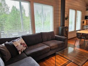 a living room with a couch and a stove at Villa Chalet - 10 hlö, Himos Länsihuippu in Jämsä