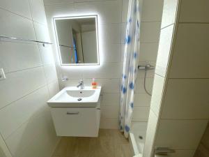 a white bathroom with a sink and a shower at Adler 82 in Leukerbad +25 photos