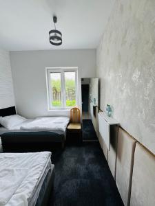 a hotel room with two beds and a window at Hotel Leśny Korne koło Kościerzyny - Kaszuby in Korne