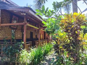 a house in the middle of a garden at Pandan Arum Surfing in Pulau Lutung