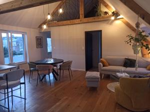 a living room with a couch and a table and chairs at Sous les Étoiles de Gaume in Virton