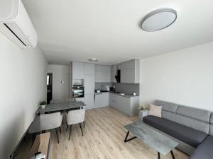 a kitchen and living room with a couch and a table at Apartmán 43G in Trnava