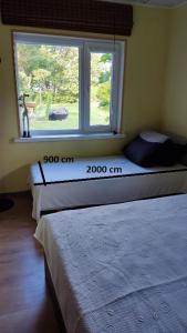 two beds in a room with a window at Mereliivatee in Neeme