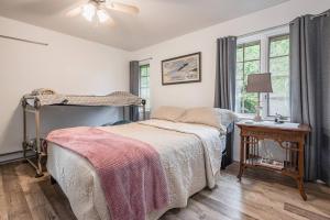 een slaapkamer met een bed, een tafel en ramen bij Surrounded By Water, W Hot Tub & Lounges in Miller Lake +39 foto's