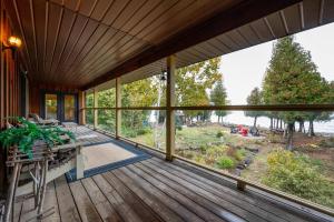 een grote afgeschermde veranda met uitzicht op het water bij Surrounded By Water, W Hot Tub & Lounges in Miller Lake