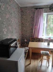 a kitchen with a table and a table and a window at Flowery apartment in Jūrmala