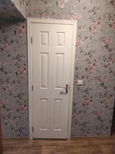 a white door in a room with floral wallpaper at Flowery apartment in Jūrmala +2 photos