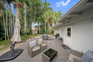 a wooden deck with chairs and an umbrella at Large Home Wking Bed By Pmi Unit Bh in Fort Lauderdale
