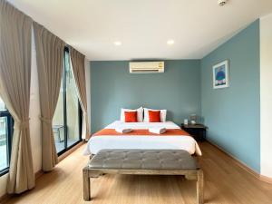 a bedroom with a bed with blue walls at Suntria Hotel Pattaya in Na Jomtien