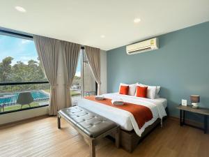 a bedroom with a large bed and a large window at Suntria Hotel Pattaya in Na Jomtien