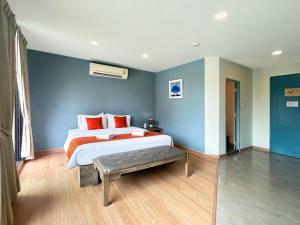a bedroom with a bed and a blue wall at Suntria Hotel Pattaya in Na Jomtien +57 photos