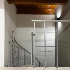 a staircase with metal rails and a wooden ceiling at La Tulè in Popoli