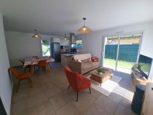 una sala de estar con un sofá y una mesa en Maison Cosy T4 proche de la mer, en Saint-Brévin-lʼOcéan