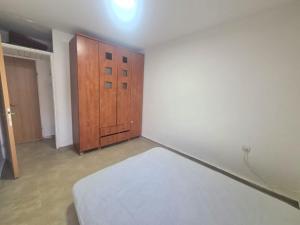 een kamer met een bed en een houten kast bij Family vacation in Tiberias