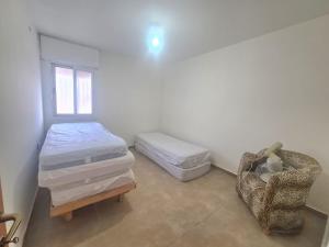 een slaapkamer met een bed, een stoel en een raam bij Family vacation in Tiberias