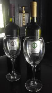 two wine glasses sitting next to two bottles of wine at Feevos in Piraeus