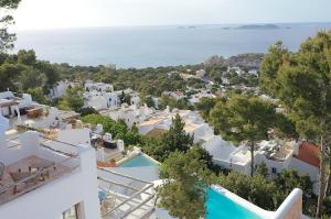 a view of a town with white buildings and the ocean at JAMES SIB19 - luxury Cala Vadella villa with pool and stunning sea view in Sant Josep de Sa Talaia