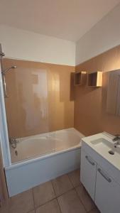 a bathroom with a bath tub and a sink at Studio Albatros en RDJ avec Terrasse, Parking privé, Piscine, proche Golf St Donat in Mouans-Sartoux