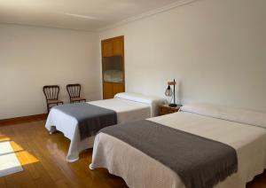 a hotel room with two beds and two chairs at El Castillo La Rioja in Agoncillo
