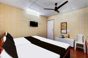 a bedroom with a large bed and a ceiling fan at Collection O Vadapalani Metro Station Vishnu's Galaxy Rooms in Chennai +11 photos