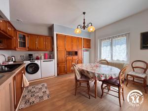 a kitchen with a table and chairs in a kitchen at Gîte Nolibo in Nogaro