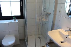 une salle de bains avec douche, toilettes et lavabo dans l'établissement Ferienhaus Nr 127, Kategorie Komfort L, Feriendorf Hochbergle, Allgäu, à Karlsebene 10 autres photos