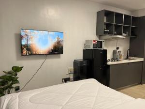 a bedroom with a tv hanging on the wall at Ohana studio homes in Nairobi