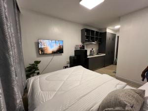 a bedroom with a bed and a tv on the wall at Ohana studio homes in Nairobi