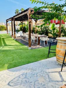 a patio with a table and chairs in the grass at El Riuet-Chalet apartamento a 1 minuto de la playa, Cullera in Cullera +32 photos