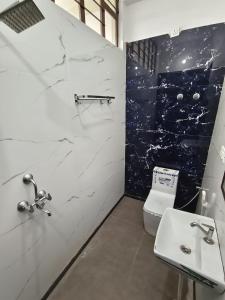 a bathroom with a toilet and a sink at AH South 2BHK Retreat w Pool Access in Jaipur